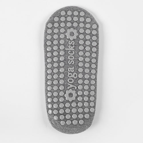 Gray Pilates and yoga sock showing the textured grip sole