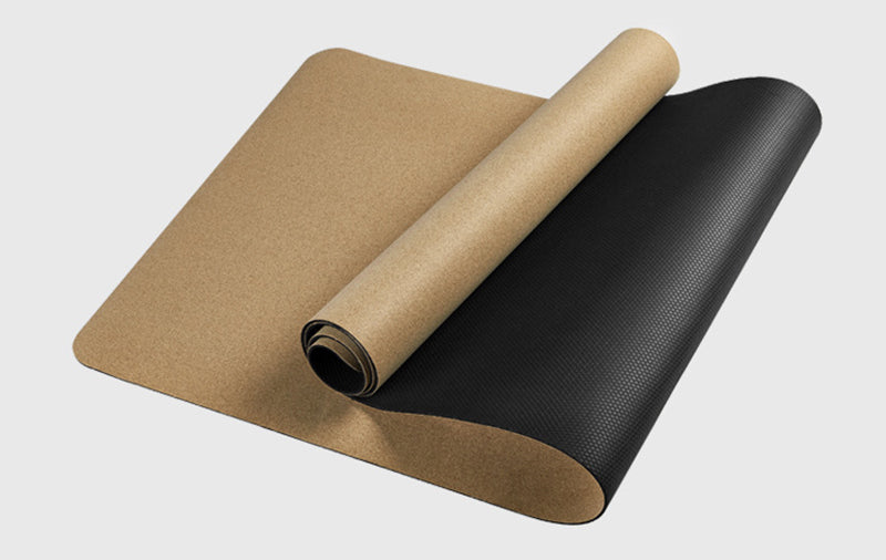 Plain cork yoga mat shown partly rolled.